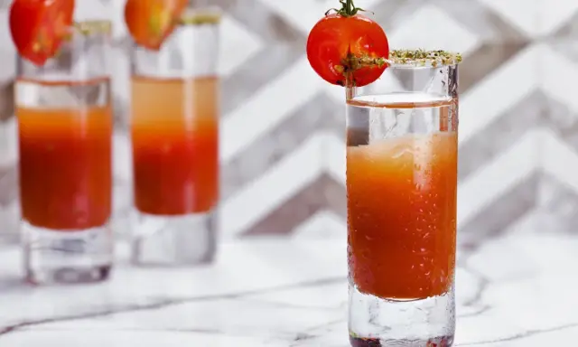 Trzy shoty z drinkiem, który wygląda jak przepis na to, jak zrobić wściekłego psa. Każdy ozdobiony pomidorkiem koktajlowym.