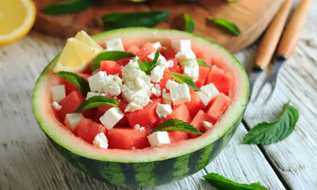 Orzeźwiająca sałatka z arbuzem, serem feta i miętą, podana w połówce arbuza. Idealna na letnie dni.