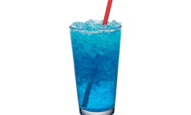 Orzeźwiający drink z blue curacao i sprite, wypełniony lodem, z czerwoną słomką.