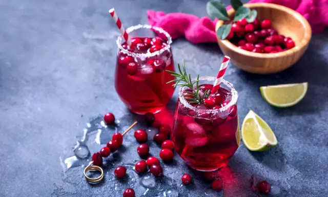 Orzeźwiający drink bezalkoholowy z grenadiną, lodem i żurawiną, udekorowany rozmarynem. Idealny na letnie popołudnie.