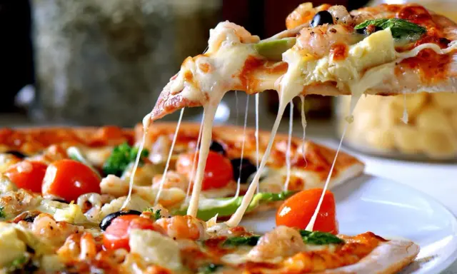 Rozciągający się ser z pizzy z krewetkami i pomidorkami. Idealna na kolację, nawet jeśli ciasto na pizzę przygotowano dzień wcześniej.