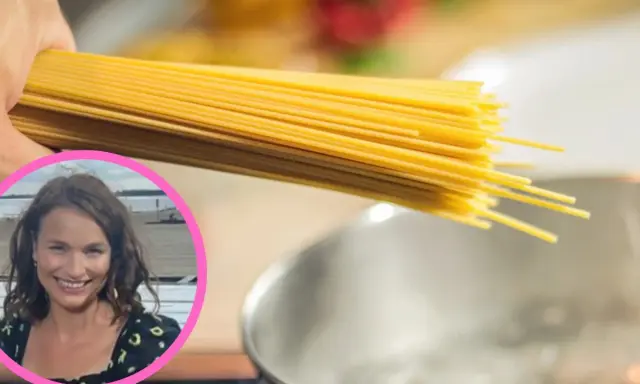 Uczymy się, ile gotować domowy makaron, by był idealny. Kobieta z uśmiechem trzyma pęczek spaghetti nad gotującą się wodą.
