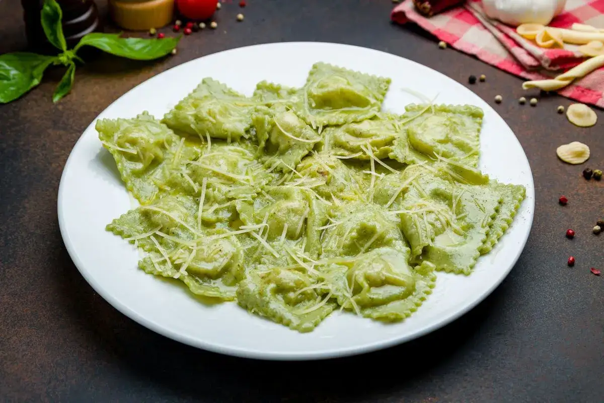 Pyszne ravioli z ricottą i szpinakiem, polane kremowym sosem i posypane parmezanem. Idealne danie dla miłośników włoskiej kuchni.