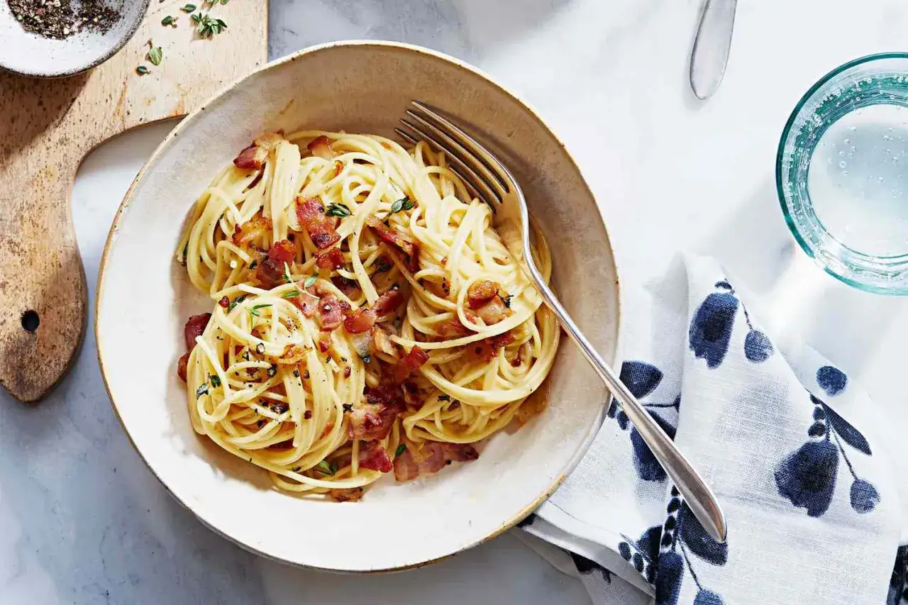 Pyszne spaghetti carbonara z chrupiącym boczkiem i ziołami. Idealny sposób, by dowiedzieć się, ile się gotuje makaron.