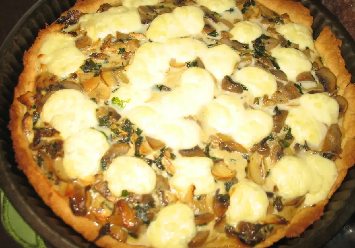 Pyszna tarta z pieczarkami i ciągnącym się serem, idealna na obiad.