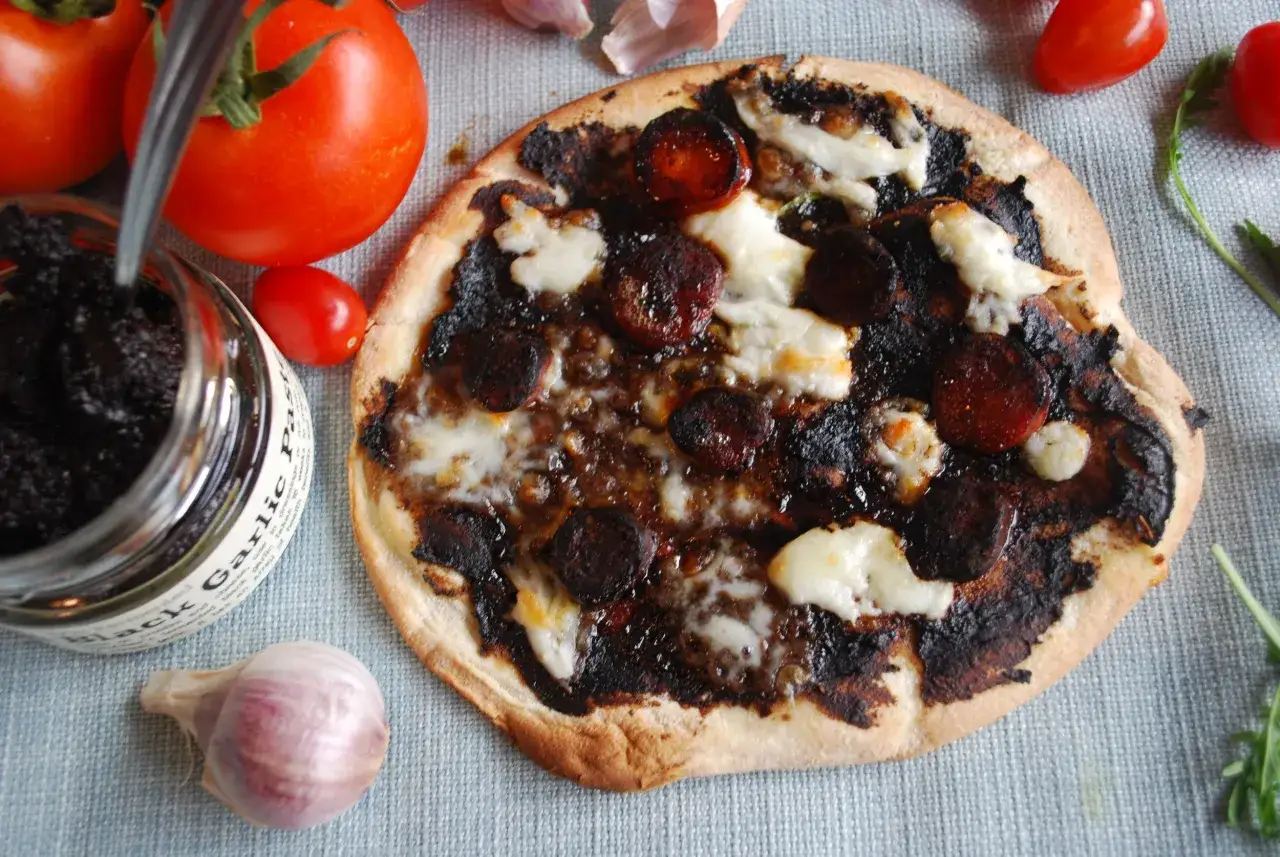 Pizza z czarnym czosnkiem, pomidorami i serem. Czarny czosnek właściwości kulinarne i zdrowotne.