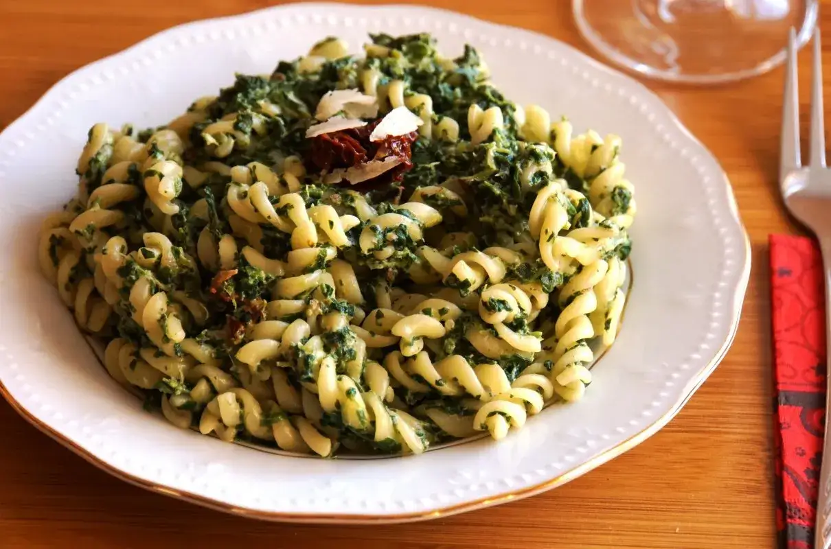 Fusilli z szpinakiem i suszonymi pomidorami, kremowe dzięki mascarpone, posypane parmezanem. Pyszne danie.