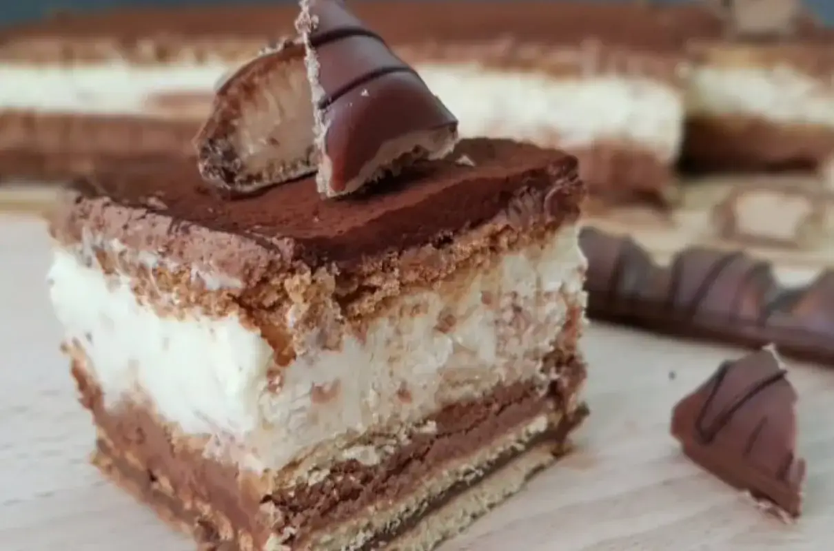 Pyszne ciasto Kinder Bueno z kremem i czekoladą, udekorowane kawałkami batonika.