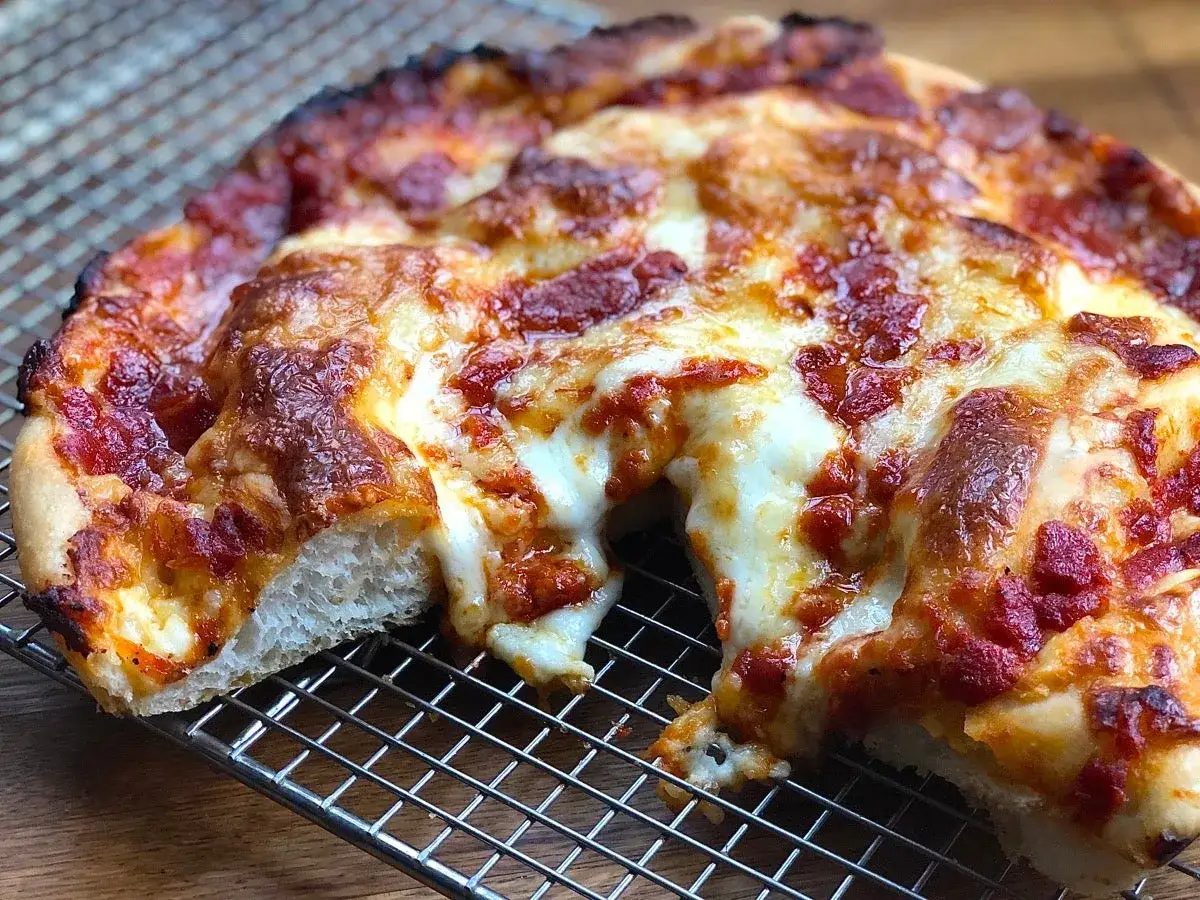 Gorąca pizza z ciągnącym się serem, pachnąca pomidorami i ziołami, czeka na swój moment. Idealny ser na pizze!