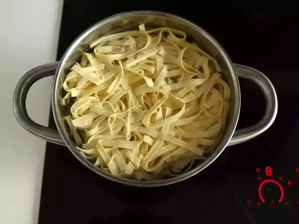 Domowy makaron w garnku na płycie indukcyjnej. Czas, ile gotować domowy makaron, zależy od jego grubości.