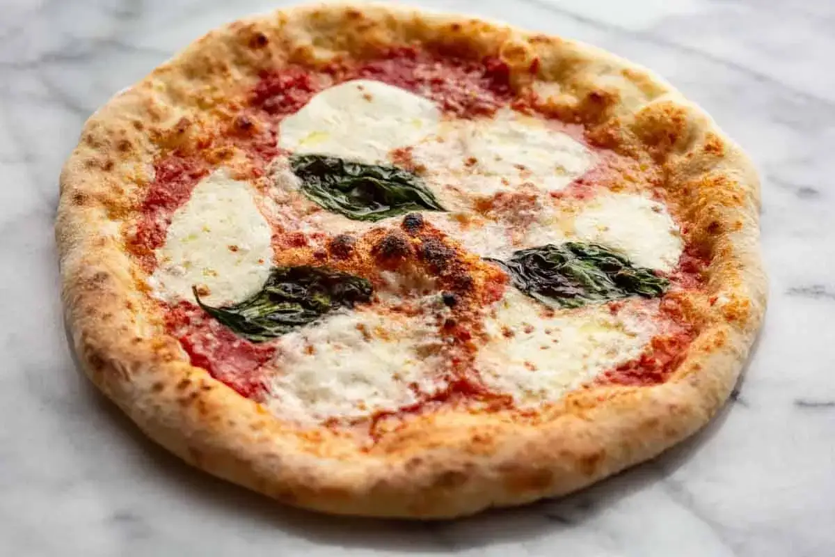 Pyszna pizza margherita z rozpływającym się serem mozzarella, sosem pomidorowym i świeżą bazylią na chrupiącym cieście.