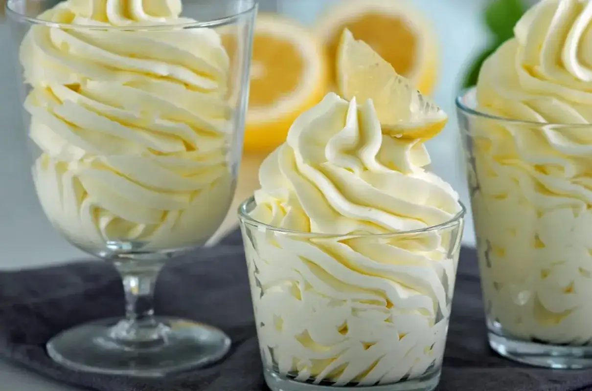 Puszysty deser o smaku cytrynowym, przypominający lekki lemon curd, podany w szklanych pucharkach.