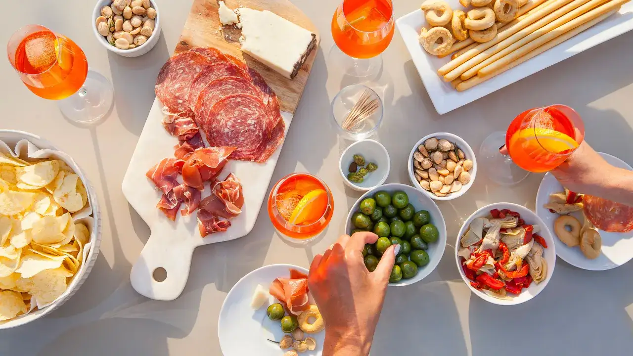 Prosecco z czym? Aperitif z oliwkami, suszonymi pomidorami, karczochami, chipsami, wędlinami, serami i paluszkami.