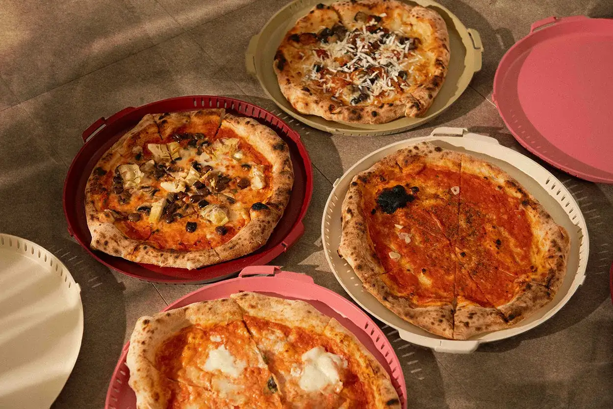 Kilka pysznych pizz w kolorowych pojemnikach. Zastanawiasz się, skąd pochodzi pizza? Z Włoch, oczywiście!