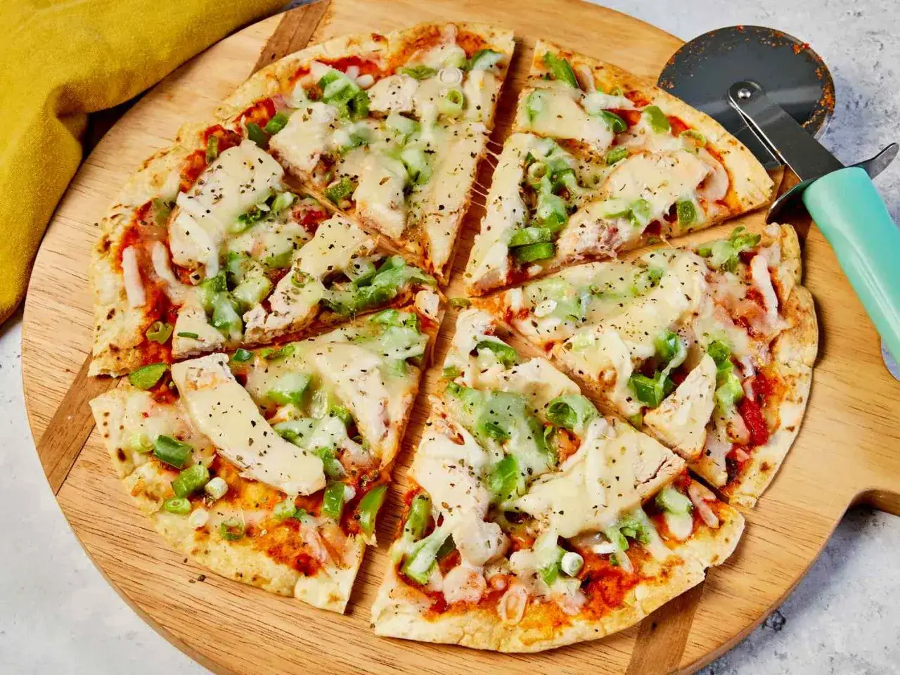 Pyszna pizza z tortilli z kurczakiem i warzywami, pokrojona na kawałki, gotowa do podania.