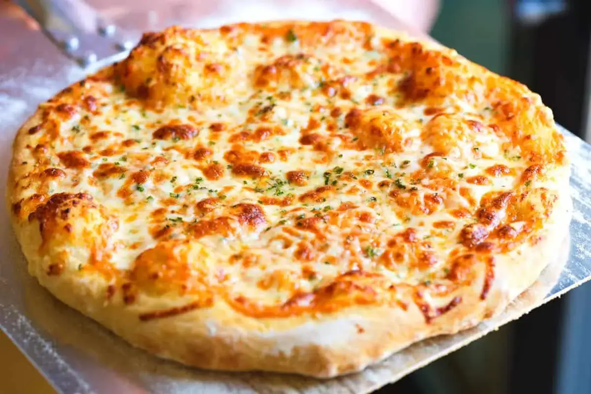 Pyszna pizza z roztopioną mozzarellą w zalewie. Czy taka mozzarella nadaje się do pizzy? Tak, idealnie!