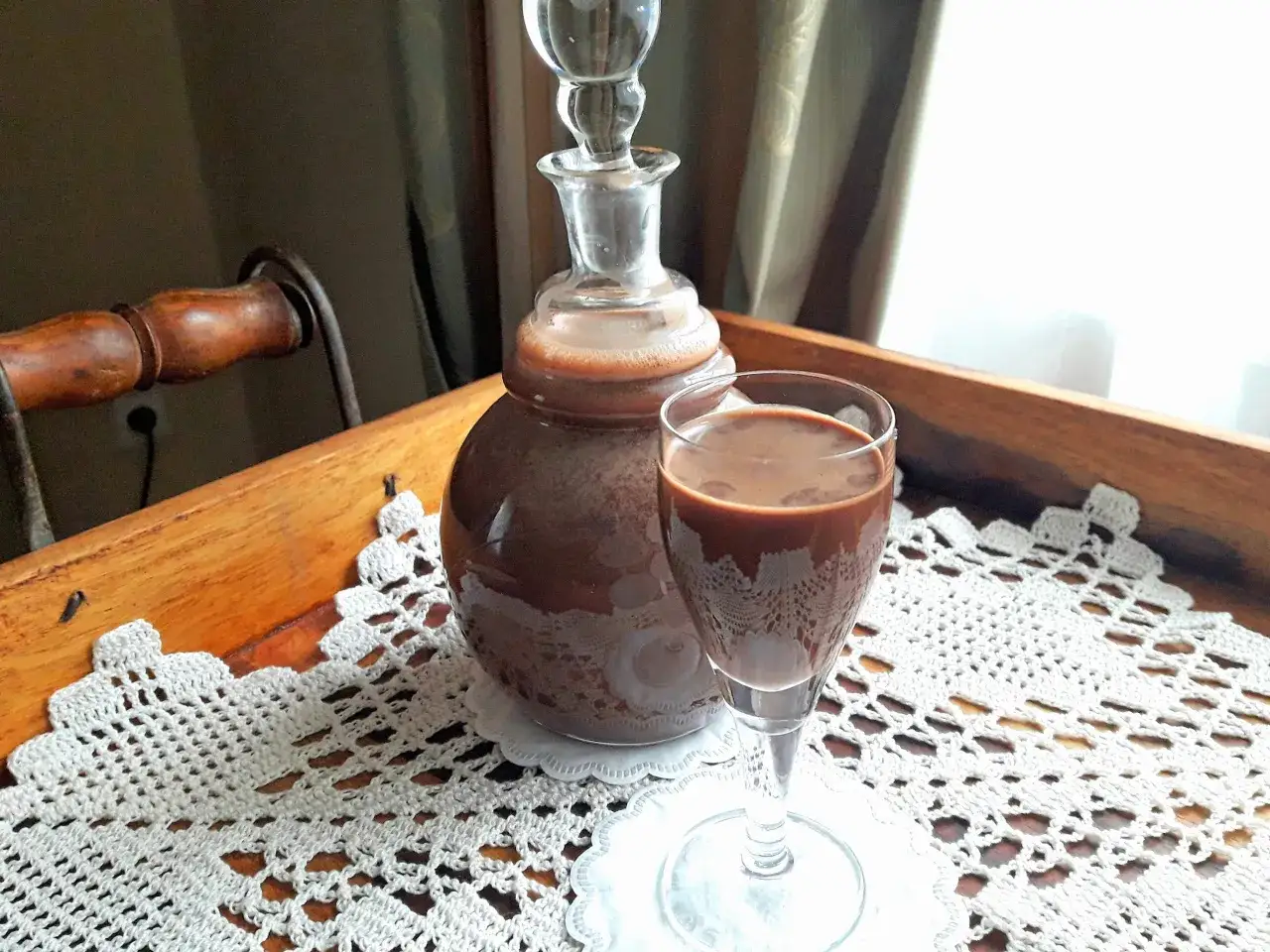 Domowy likier czekoladowy w karafce i kieliszku, gotowy do degustacji. Idealny na prezent lub jako dodatek do deserów.