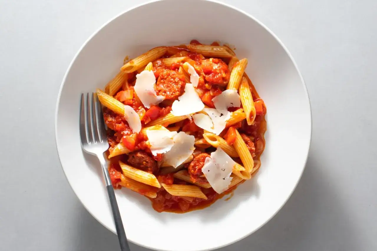 Penne z pikantnym chorizo w sosie pomidorowym, posypane wiórkami parmezanu. Idealne danie dla miłośników wyrazistych smaków.