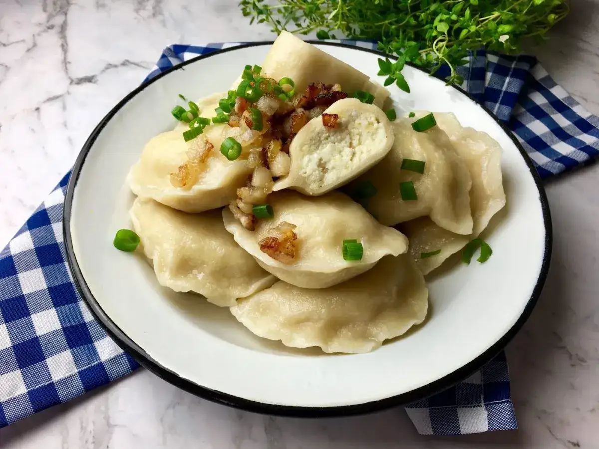 Pyszne pierogi ruskie z cebulką i szczypiorkiem, idealne na obiad.