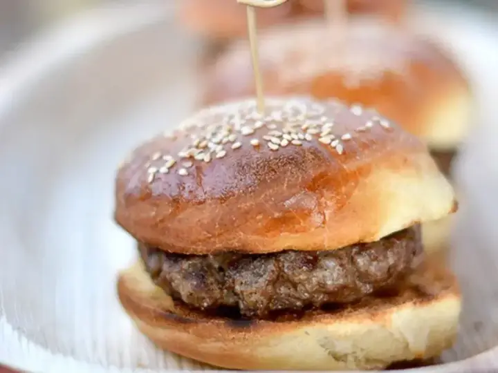Mini burgery na talerzu, z sezamem na wierzchu. Idealne bułki do burgerów na przyjęcie.